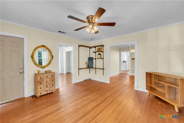 a view of a livingroom with furniture wooden floor and a ceiling fan