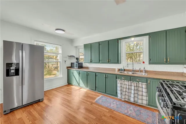 a kitchen with stainless steel appliances a refrigerator sink and cabinets