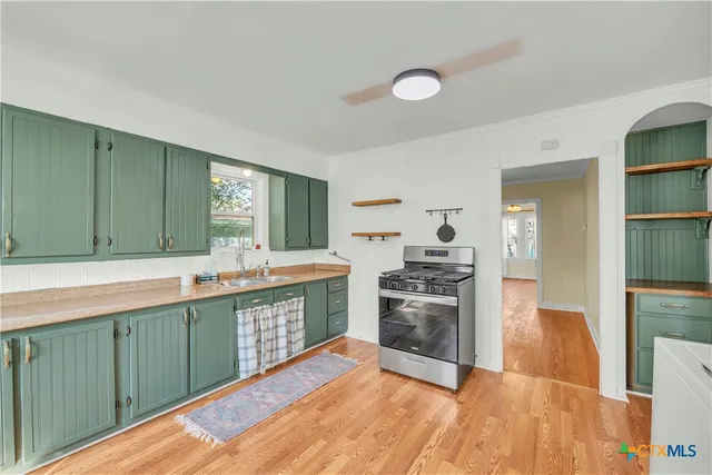 a large kitchen with stainless steel appliances granite countertop a stove and a sink