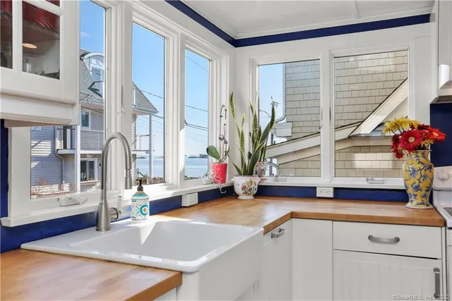 a view of living room kitchen with stainless steel appliances wooden floor and window