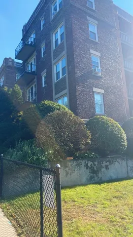 a view of a brick house next to a yard