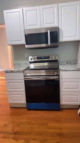 a kitchen with stainless steel appliances granite countertop a stove and a microwave