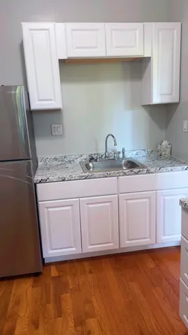 a kitchen with granite countertop a sink a stove a washer and dryer