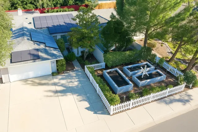 a view of a house with pool and wooden fence