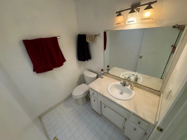 a bedroom with a bed and a mirror on dresser