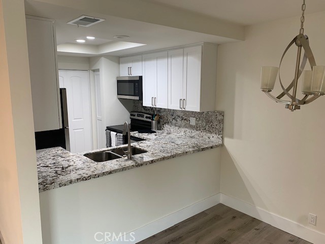 2275 Hazel Road Tustin, CA 92780 - Photo 5 of 25 a kitchen with stainless steel appliances granite countertop a sink refrigerator and microwave