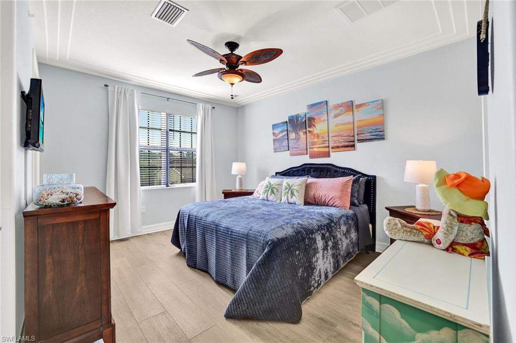 9115 Capistrano Street South, Unit 8207 Naples, FL 34113 - Photo 11 of 29 a bedroom with a bed and wooden floor