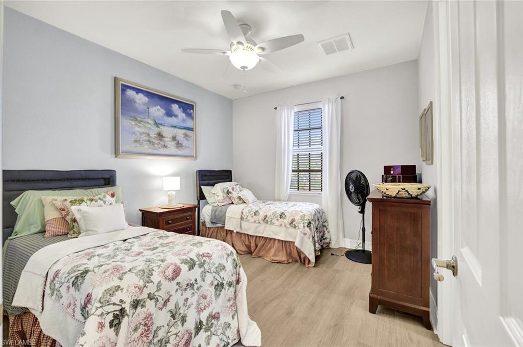9115 Capistrano Street South, Unit 8207 Naples, FL 34113 - Photo 14 of 29 a bedroom with two bed and a chandelier