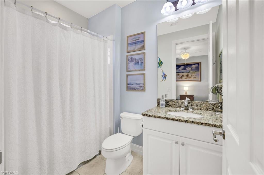 9115 Capistrano Street South, Unit 8207 Naples, FL 34113 - Photo 15 of 29 a bathroom with a granite countertop sink and a mirror