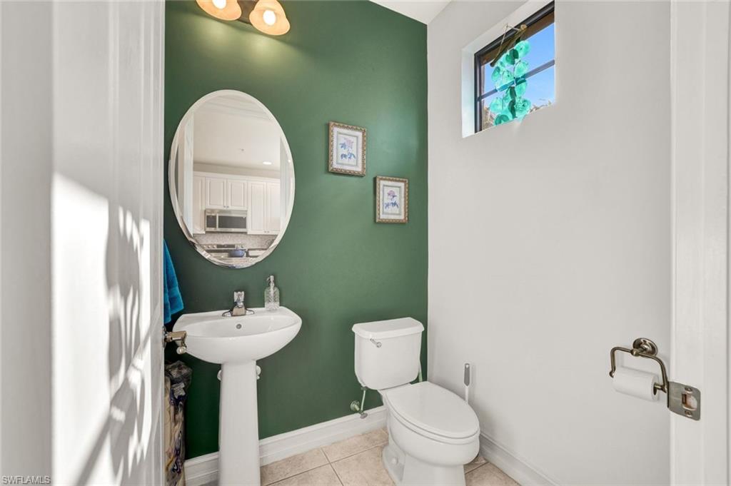9115 Capistrano Street South, Unit 8207 Naples, FL 34113 - Photo 16 of 29 a bathroom with a toilet sink and mirror