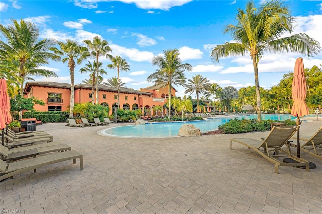 9115 Capistrano Street South, Unit 8207 Naples, FL 34113 - Photo 20 of 29 a row of palm trees and swimming pool in the garden