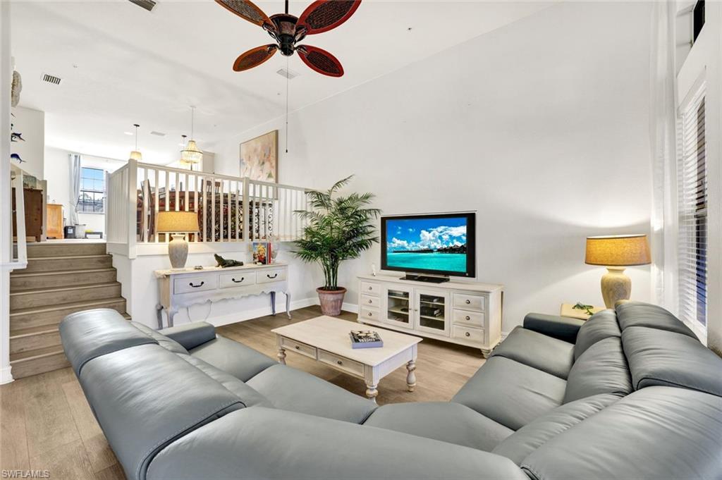 9115 Capistrano Street South, Unit 8207 Naples, FL 34113 - Photo 4 of 29 a living room with furniture and a flat screen tv