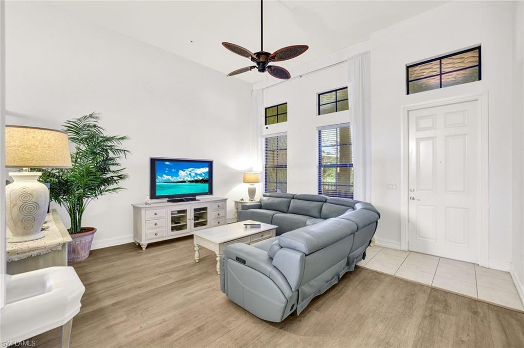 9115 Capistrano Street South, Unit 8207 Naples, FL 34113 - Photo 5 of 29 a living room with furniture and a flat screen tv