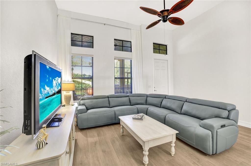 9115 Capistrano Street South, Unit 8207 Naples, FL 34113 - Photo 6 of 29 a living room with furniture and a flat screen tv