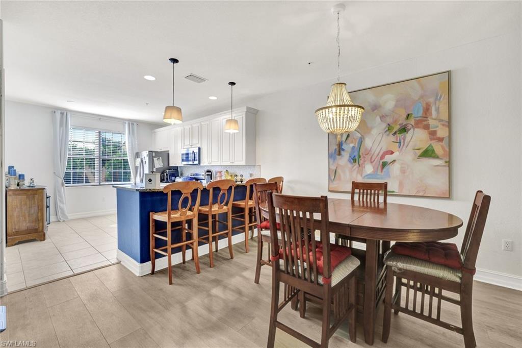 9115 Capistrano Street South, Unit 8207 Naples, FL 34113 - Photo 8 of 29 a dining room with furniture and window