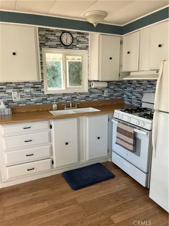 a kitchen with granite countertop white cabinets appliances and a large window