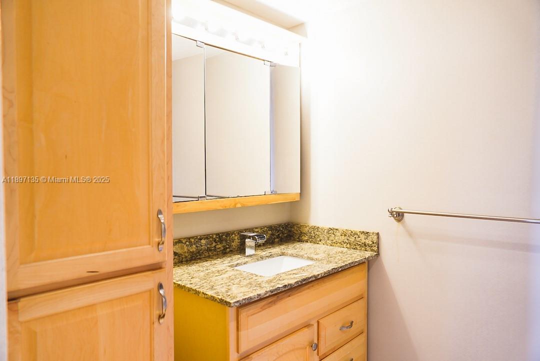100 Golden Isles Drive, Unit 10 Hallandale Beach, FL 33009 - Photo 11 of 18 a bathroom with a granite countertop sink and a mirror