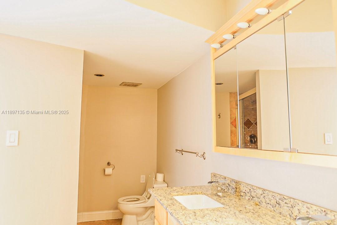 100 Golden Isles Drive, Unit 10 Hallandale Beach, FL 33009 - Photo 12 of 18 a bathroom with a granite countertop sink and a mirror