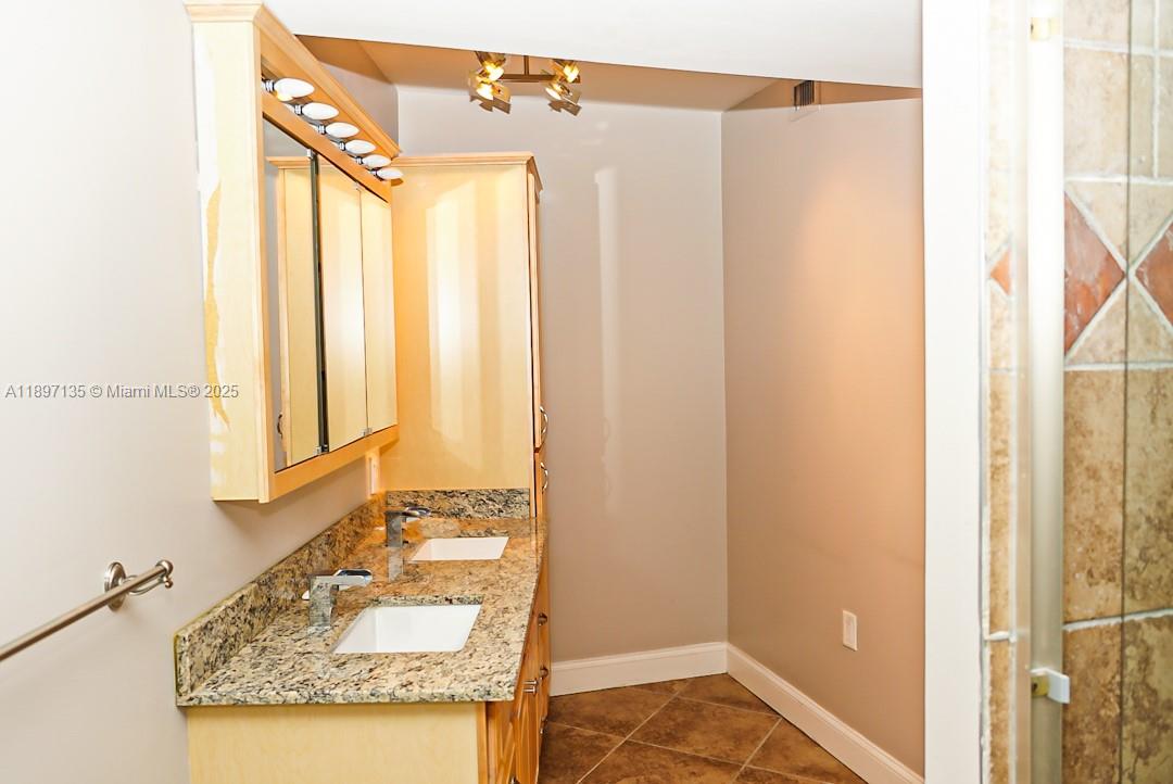 100 Golden Isles Drive, Unit 10 Hallandale Beach, FL 33009 - Photo 14 of 18 a bathroom with a granite countertop sink and a mirror