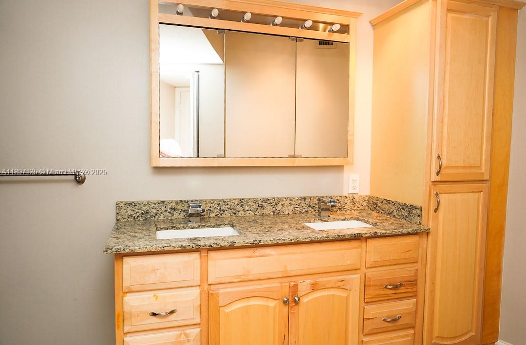 100 Golden Isles Drive, Unit 10 Hallandale Beach, FL 33009 - Photo 15 of 18 a bathroom with a granite countertop sink and a mirror