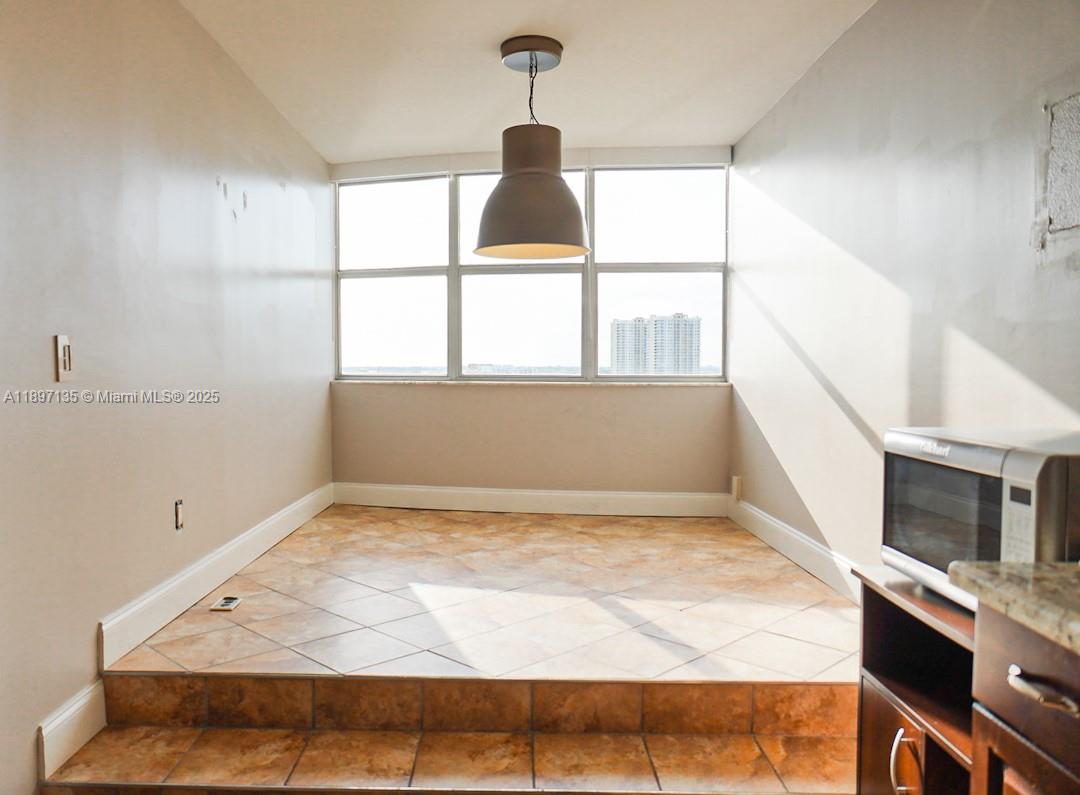 100 Golden Isles Drive, Unit 10 Hallandale Beach, FL 33009 - Photo 6 of 18 a view of empty room with wooden floor and fan