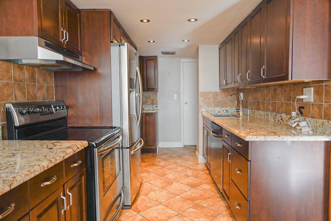 100 Golden Isles Drive, Unit 10 Hallandale Beach, FL 33009 - Photo 7 of 18 a kitchen that has a sink a stove and a refrigerator