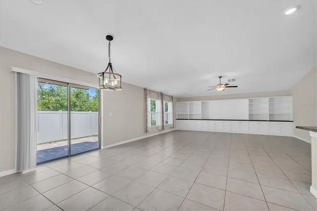 a view of a livingroom with a chandelier fan and windows