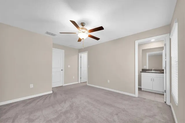 an empty room with closet and windows