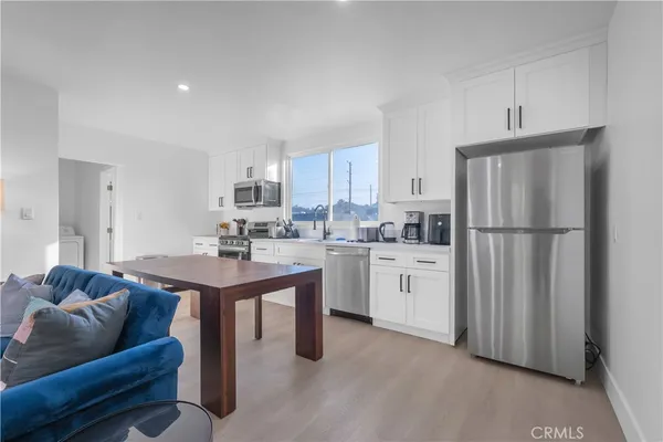 a kitchen with white cabinets and refrigerator