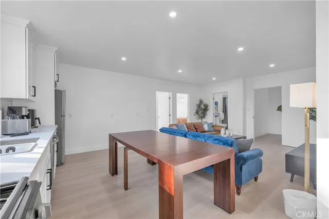 a kitchen with stainless steel appliances a table and chairs