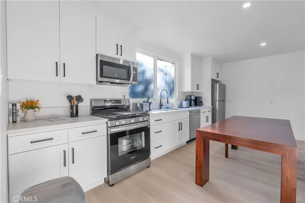 a kitchen with a sink cabinets and wooden floor