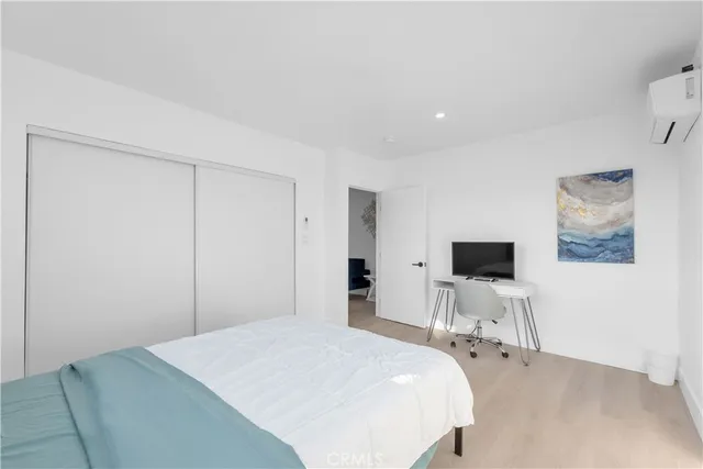 a bedroom with a bed and a flat screen tv