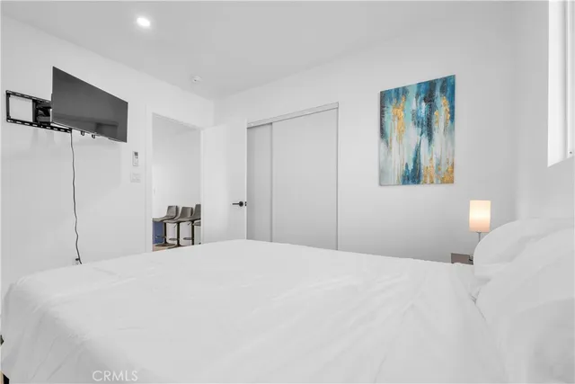 a bedroom with a bed and a flat screen tv