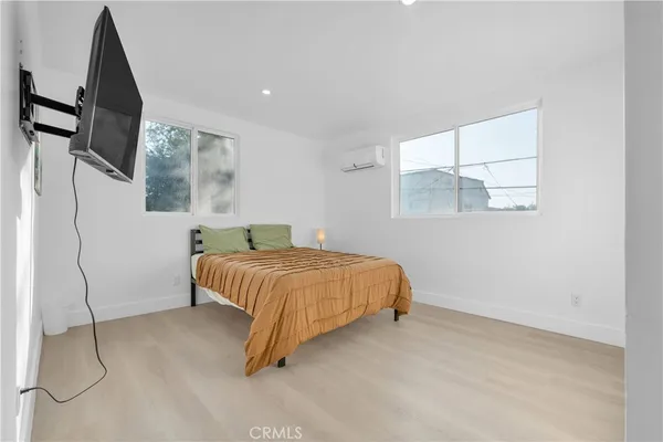 a bedroom with a bed window and flat screen tv