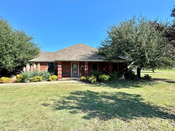 a view of a house with a yard and tree s