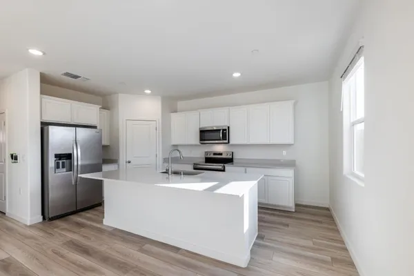 a kitchen with stainless steel appliances a refrigerator sink and microwave