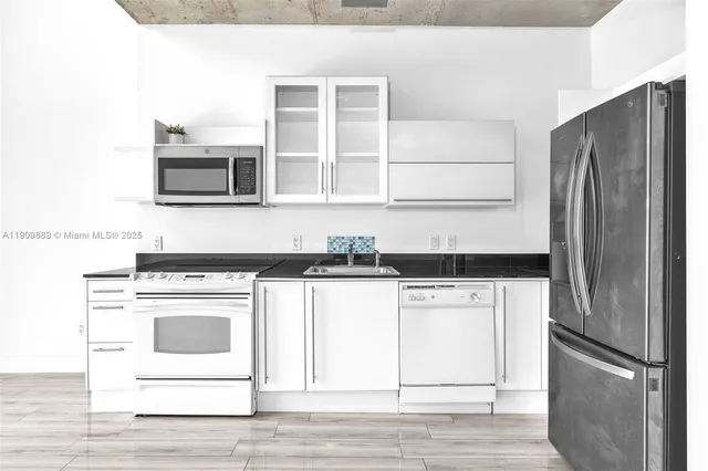 a kitchen with stainless steel appliances granite countertop a stove a refrigerator and a microwave