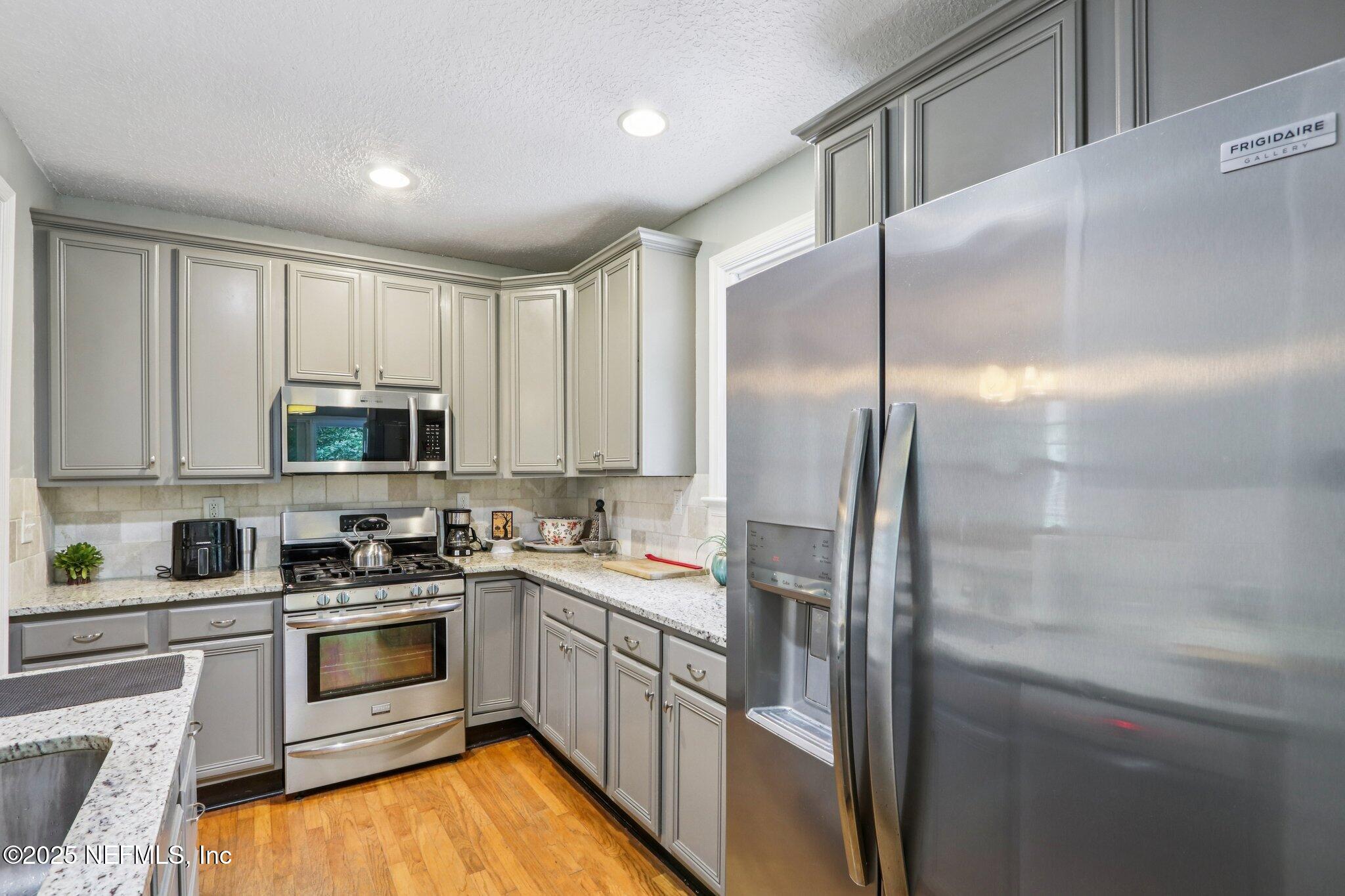 1605 Lorimier Road Jacksonville, FL 32207 - Photo 28 of 57 a kitchen with a sink a counter top space stainless steel appliances and cabinets