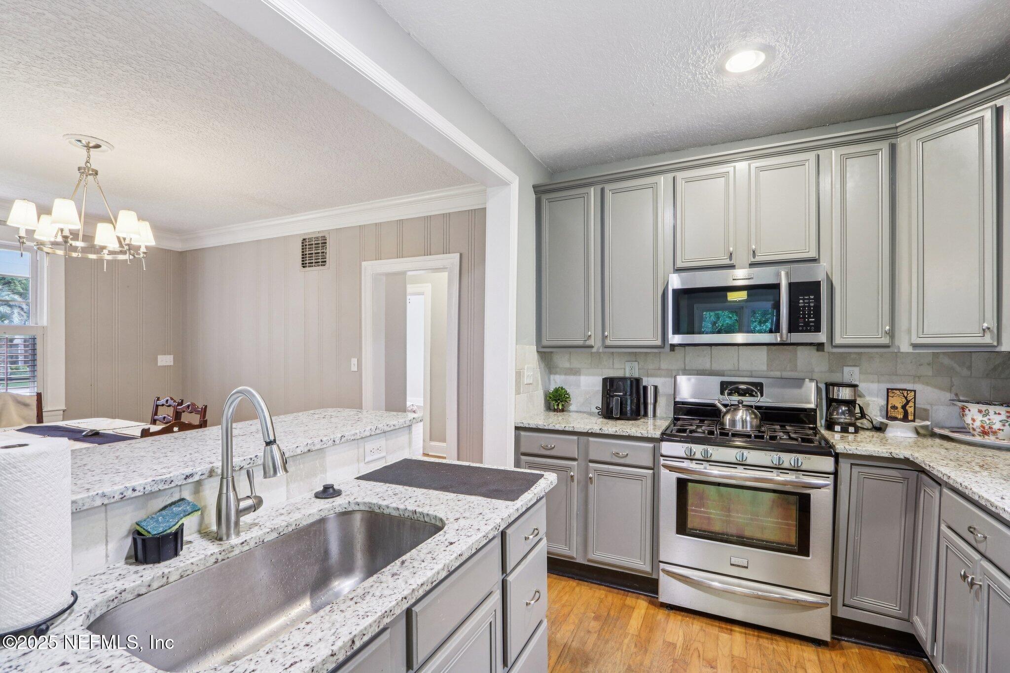 1605 Lorimier Road Jacksonville, FL 32207 - Photo 29 of 57 a kitchen with granite countertop a sink a stove and cabinets