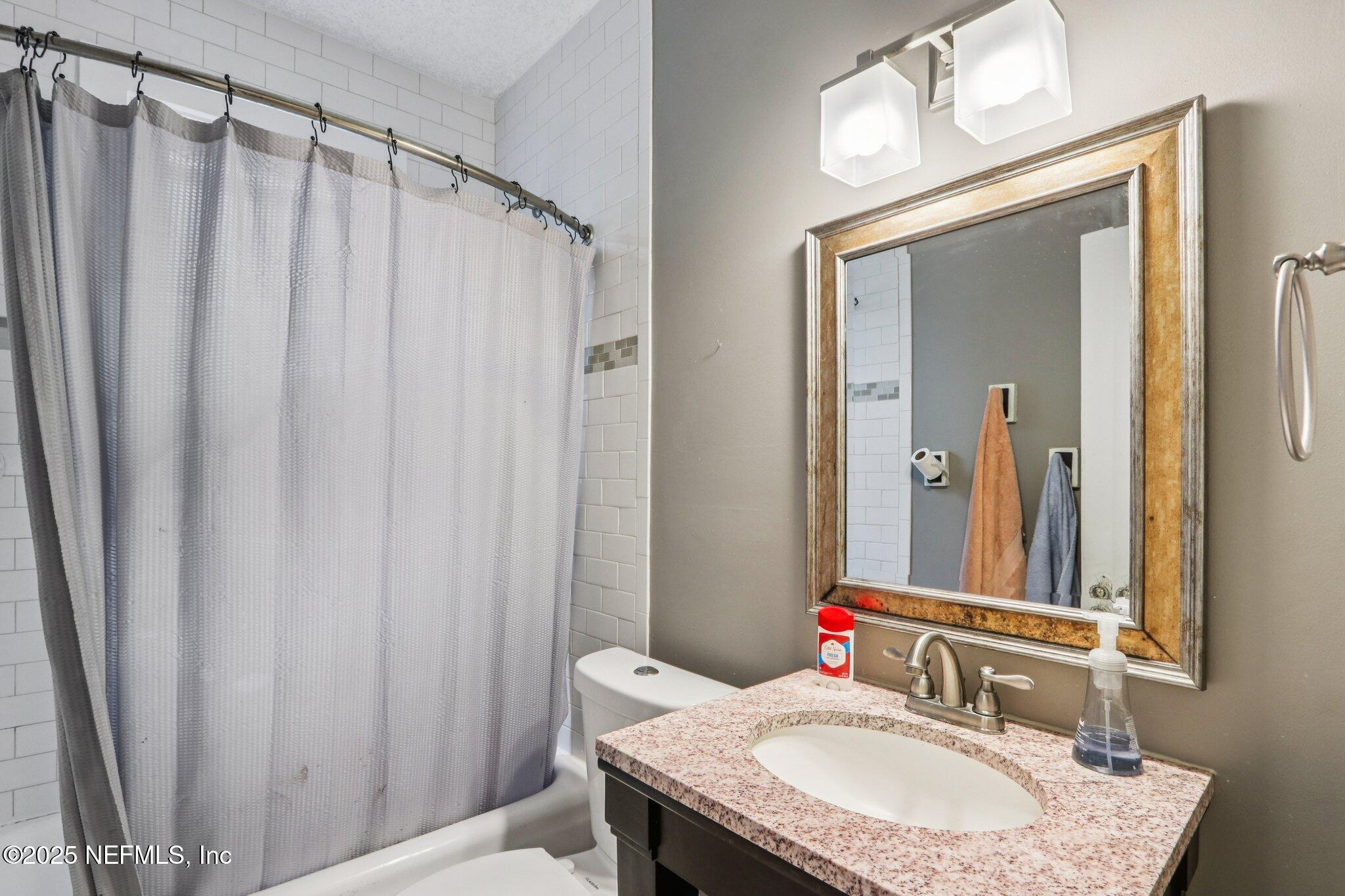 1605 Lorimier Road Jacksonville, FL 32207 - Photo 30 of 57 a bathroom with a granite countertop sink and a mirror