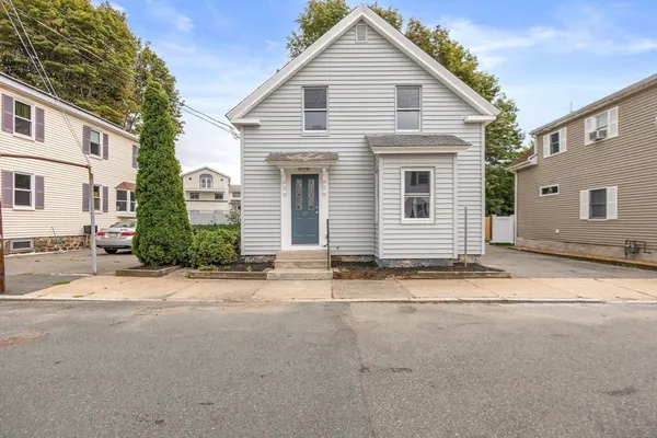 a view of a house with a backyard and road