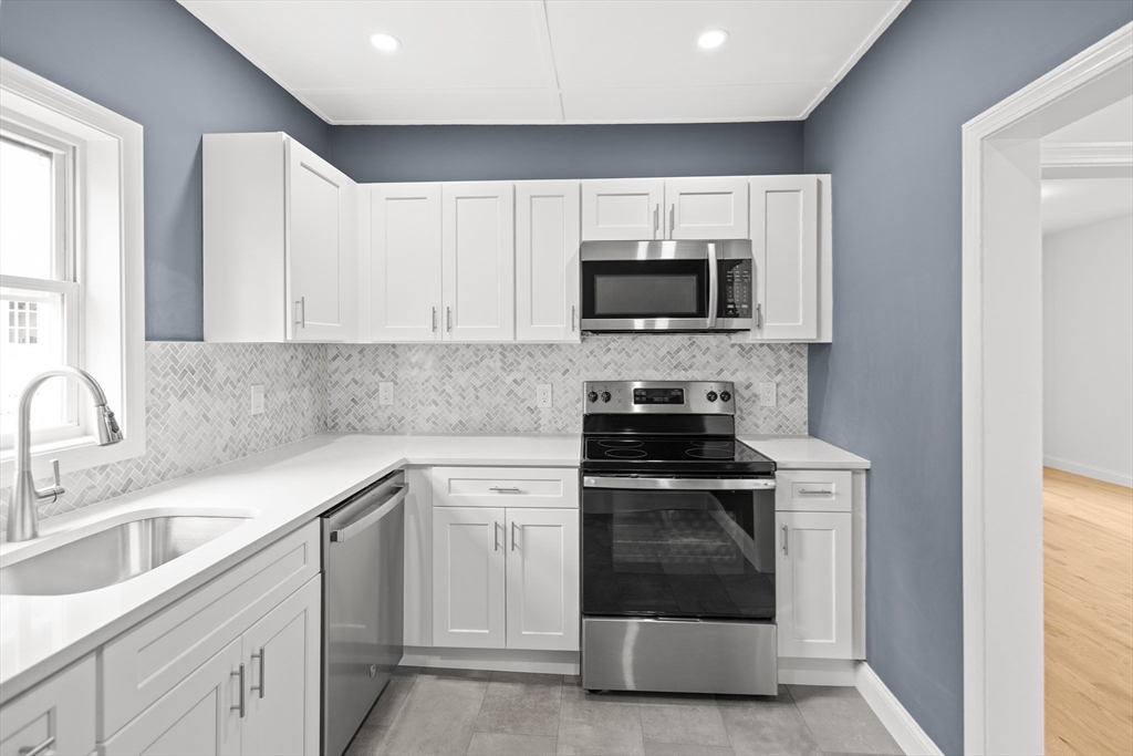 57 Ord Street Salem, MA 01970 - Photo 11 of 40 a kitchen with white cabinets appliances and sink