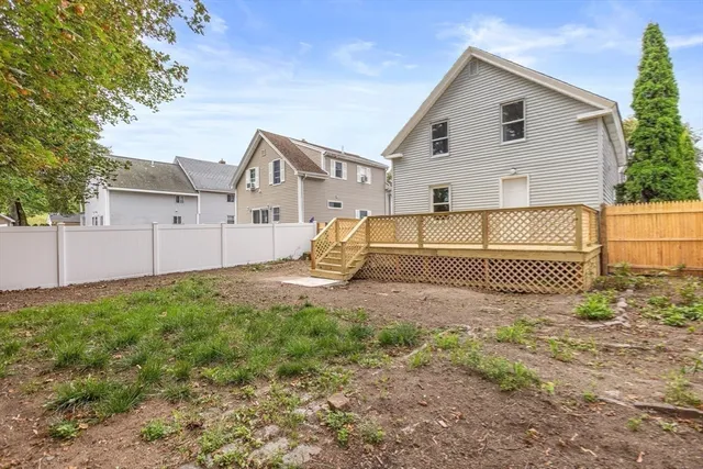 a view of a house with a yard and a large tree