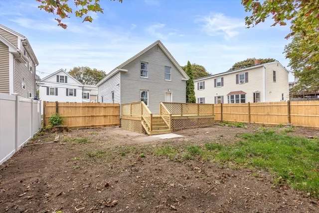 a view of a yard with a house and wooden fence