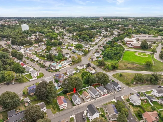 an aerial view of residential houses with outdoor space and trees