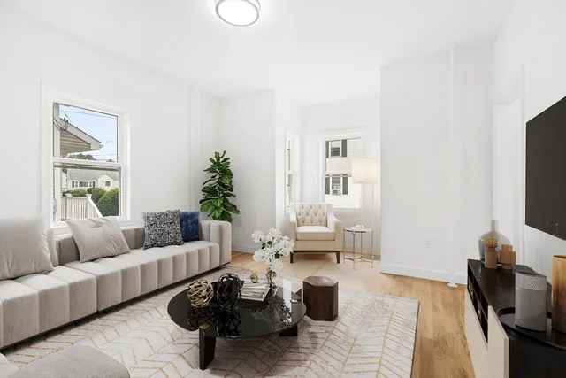 a living room with furniture a rug and a flat screen tv