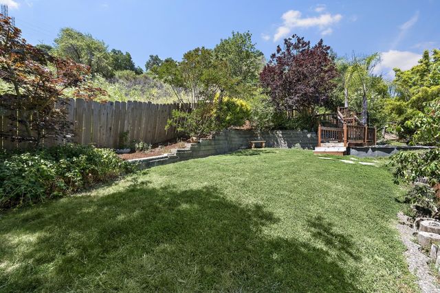 a view of a backyard with sitting area and tree