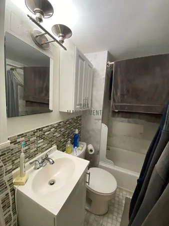 a bathroom with a sink toilet and shower