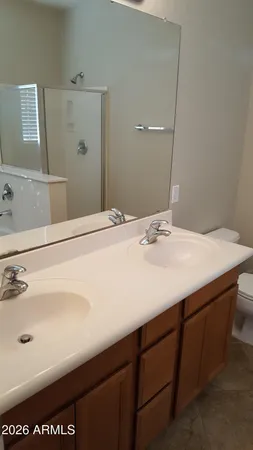a view of a hallway with wooden floor and a bathroom