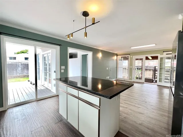 a kitchen with granite countertop a stove and wooden floor